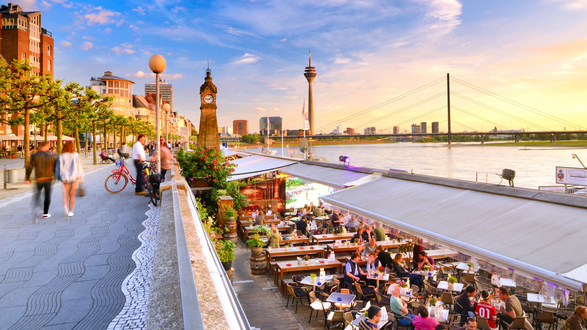 Düsseldorf: Rhine promenade at sunset with the Rhine Tower in the background